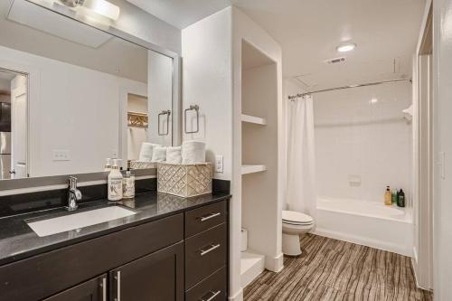 y baño con lavabo, aseo y espejo. en Five Star Hotel-Style 2BD-Apartment at the Domain Shopping Center en Austin