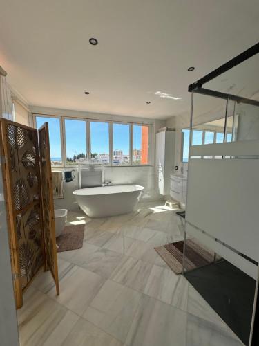 a large bathroom with a tub and a large window at Luxury villa in the heart of the city of Marbella Spain. in Marbella