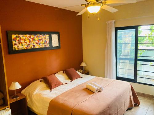 a bedroom with a bed and a ceiling fan at Posada Boutique Le Vrero in Colonia del Sacramento