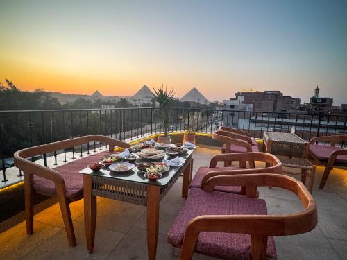 a table with plates of food on top of a balcony at Jimmy Pyramids Hotel in Cairo