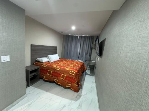 ein Schlafzimmer mit einem Bett mit einer roten Decke in der Unterkunft Hotel Fuego Bronx in Bronx