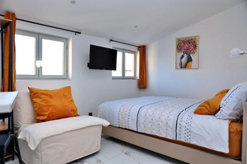 - une chambre avec un lit, une chaise et une télévision dans l'établissement Soleil du Sud Marseille StCharles Reformes Vieux Port, à Marseille