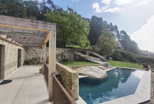a backyard with a pool and a wooden walkway at Quinta do Penedo Real in Viana do Castelo