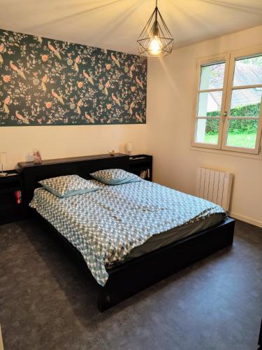 - une chambre avec un lit orné d'un mur fleuri dans l'établissement La curieuse petite maison, à Vendôme