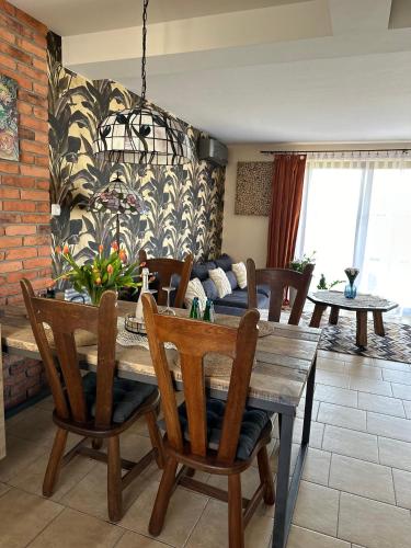 a dining room with a wooden table and chairs at Piękna Góra in Giżycko