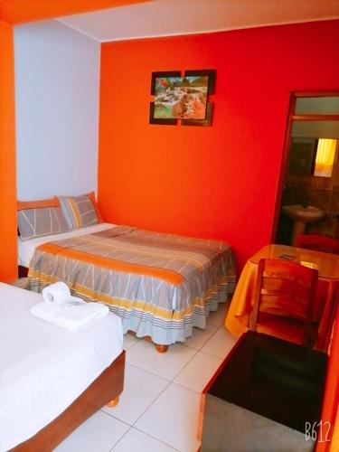 una camera con due letti e una parete rossa di Confort pichanaki a Pichanaki