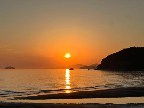 einen Sonnenuntergang am Strand mit Sonnenuntergang in der Unterkunft ASTERISK＋ in Iwami