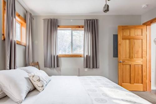 a bedroom with a large white bed and a window at Serene Retreat on a Stream in Phoenicia