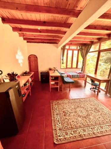 sala de estar con escritorio y mesa con alfombra en Beautiful Cabin at Gaia Temple en Tzununá