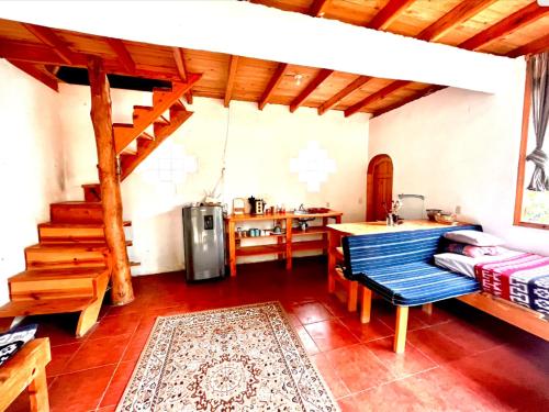 a living room with a staircase and a kitchen at Beautiful Cabin at Gaia Temple in Tzununá