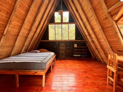 Beautiful Cabin at Gaia Temple في Tzununá: غرفة نوم مع سرير في كابينة خشب