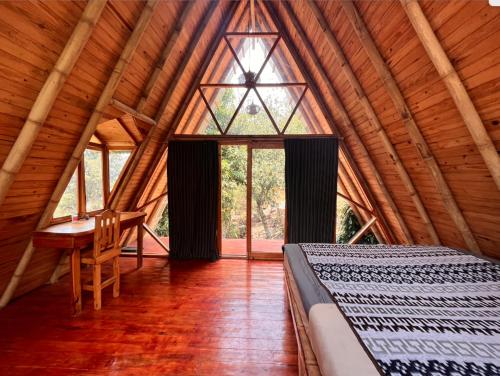 Beautiful Cabin at Gaia Temple في Tzununá: غرفة نوم بسرير ومكتب في غرفة