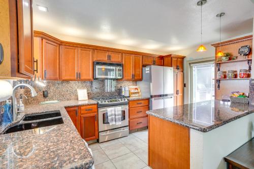 a kitchen with wooden cabinets and a stove top oven at Lovely Tustin Home with Outdoor Kitchen 3 Mi to Zoo in Tustin
