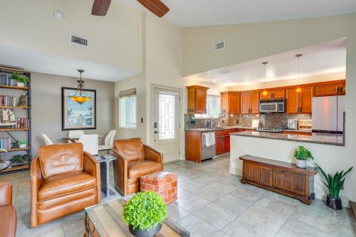 a living room with two chairs and a kitchen at Lovely Tustin Home with Outdoor Kitchen 3 Mi to Zoo in Tustin