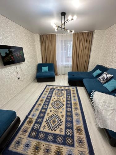 ЖК Шахтеров 52 А في كاراغاندي: غرفة معيشة مع أريكة زرقاء وسجادة
