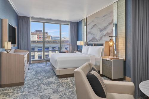 ポートランドにあるThe Ritz-Carlton, Portlandのベッドと大きな窓が備わるホテルルームです。