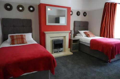 a bedroom with two beds and a fire place at Large 4 Bed House, Sleeps 7, Near NEC, BHX, City Centre in Birmingham