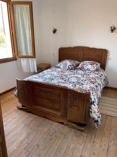 a bed with a wooden frame in a bedroom at Jad in Moustiers-Sainte-Marie