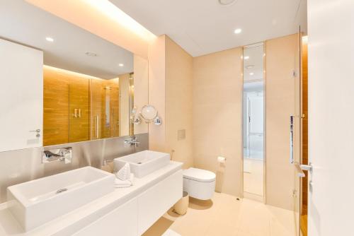 a bathroom with a sink and a toilet and a mirror at Premium 2+1 BR condo in the heart of Bluewaters Island in Dubai