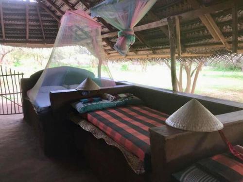 a bed in a tent with a hammock in a room at Ego Swargarajje Yala Thissamaharama in Tissamaharama