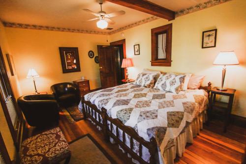 a bedroom with a bed with a quilt on it at Nightingales Inn in Ashland