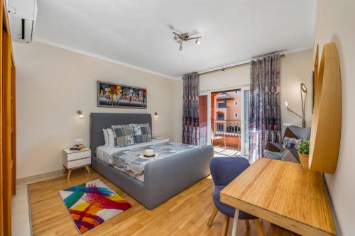 a bedroom with a bed and a table in a room at Avenue Apartment Vilamoura in Quarteira