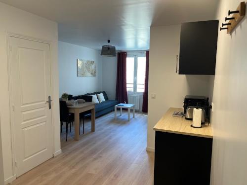 une cuisine et un salon avec une table et un canapé dans l'établissement WD Saint Roch - Appartement 102 - Métro 7 Proche Paris, à Villejuif