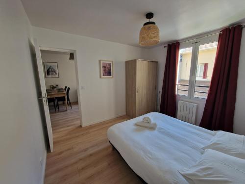 une chambre avec un lit, une table et une fenêtre dans l'établissement WD Saint Roch - Appartement 102 - Métro 7 Proche Paris, à Villejuif