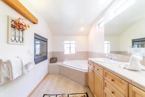 a bathroom with a tub and a sink at 593 New June Lake Condo in June Lake