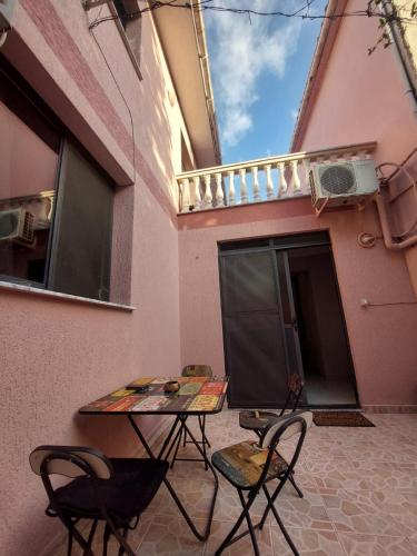 eine Terrasse mit einem Tisch und Stühlen vor einem Gebäude in der Unterkunft GEX Guest House in Tirana
