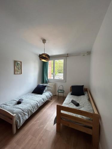 une chambre avec deux lits et une fenêtre dans l'établissement Le beau T4 Côte Pavée parking facile, à Toulouse