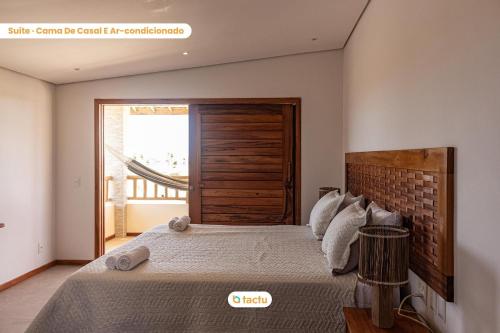 a bedroom with a large bed and a window at Casa Canoé Fortim Piscina de Luxo em Condomínio in Barra (2)