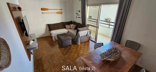 ein Wohnzimmer mit einem Sofa und einem Tisch in der Unterkunft Centro Guarapari - espaço & conforto - WI-FI in Guarapari
