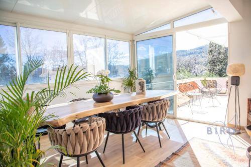 een kamer met een tafel, stoelen en ramen bij Superb renovated villa 2 steps from Seillans in Seillans