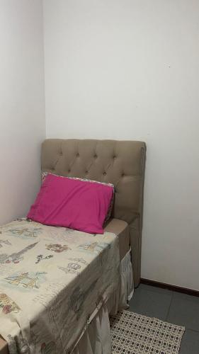 een bed met een roze kussen erop bij Quarto Privativo Zona Sul RP in Ribeirão Preto