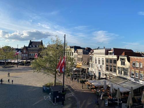 an old town with a street with cafes and buildings at Apartment City Center Terrace with Iconic View in Gouda