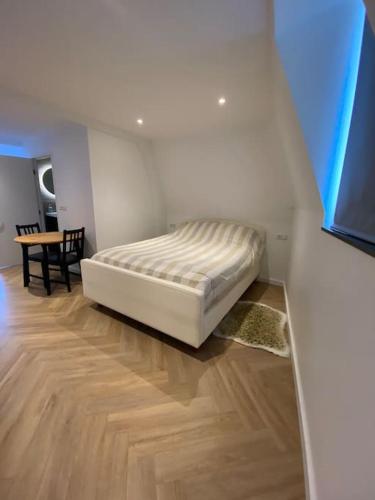 a bedroom with a bed in a room with a table at Apartment City Center Terrace with Iconic View in Gouda
