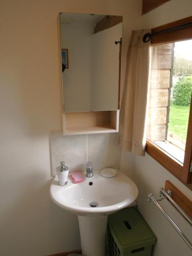 une salle de bain avec un lavabo blanc et une fenêtre dans l'établissement Acacia, à Cherbonnières