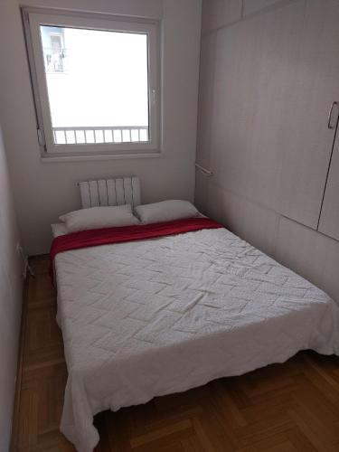 a bed in a small room with a window at Evelin Apartment in Belgrade