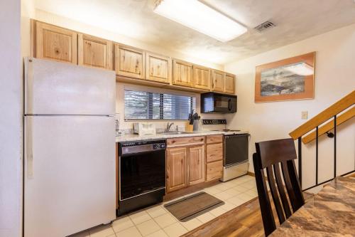 una cucina con frigorifero bianco e armadietti in legno di Four-Bedroom Apartment a Champion