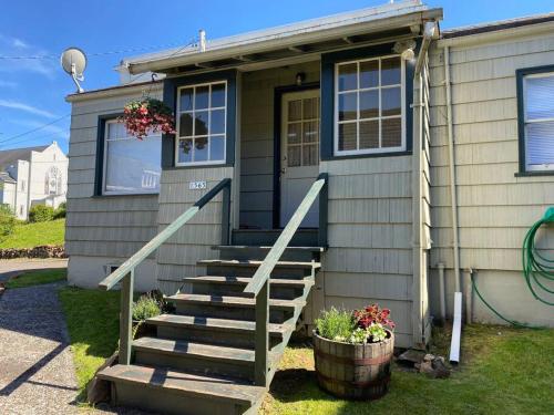 a house with a staircase leading to the front door at Historic Downtown Cottage in Astoria, Oregon