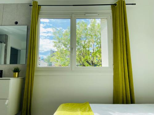 - une chambre dotée d'une fenêtre avec des rideaux verts dans l'établissement Le BARABAN, à Lyon