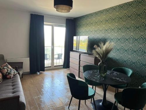 a living room with a table and chairs and a television at Apartament u Kasi in Sandomierz