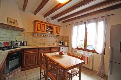 une cuisine avec une table en bois et un réfrigérateur dans l'établissement Les puits, à Champagnac-la-Rivière