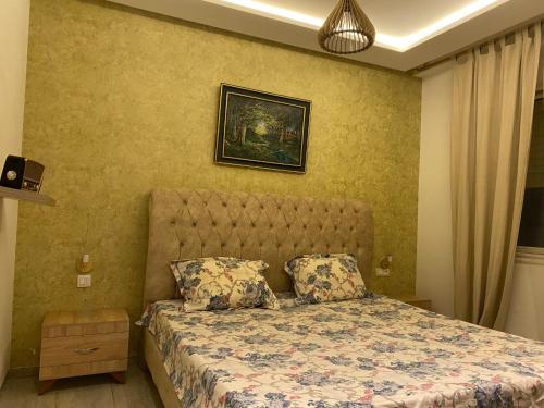 - une chambre avec un lit et une photo sur le mur dans l'établissement Coquette appartement sahloul 4, à Sousse