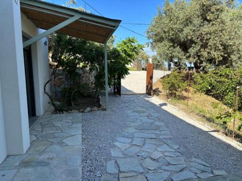 a stone walkway leading to a building with a wooden roof at Tierra in Skiathos Town