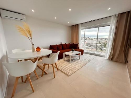 un salon avec un canapé, une table et des chaises dans l'établissement Prestige - 4 pers Neuf Vue Mer - Hyper centre, à Saint-Raphaël