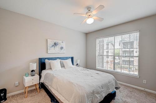 Schlafzimmer mit einem Bett, einem Deckenventilator und einem Fenster in der Unterkunft Urban Haven near NRG Stadium in Houston