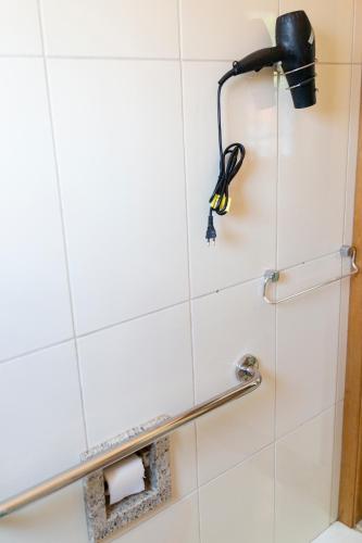 a shower stall with a shower head and a toilet paper holder at pousada Anna Assumpta in Severínia