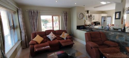 a living room with a couch and two chairs at Mortara Cottage V31KV24 in Ballylongford